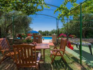 カンファナルにあるApartment Ivan & Tina-1 by Interhomeのテーブルと椅子とプールのあるパティオ