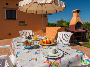 einen Tisch mit einem Obstteller und einem Regenschirm in der Unterkunft Holiday Home Arancio by Interhome in Preselle