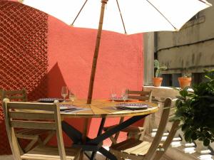 a table with wine glasses and an umbrella on a patio at La Terrasse du Marché aux Fleurs in Montpellier +26 photos