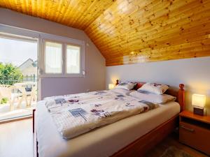 バラトンサールソーにあるApartment Swing by Interhomeの木製の天井のベッドルーム1室(大型ベッド1台付)