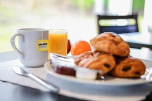 ヘイルにあるホリデイ イン エクスプレス マンチェスター エアポートの朝食用の食品とオレンジジュース1杯
