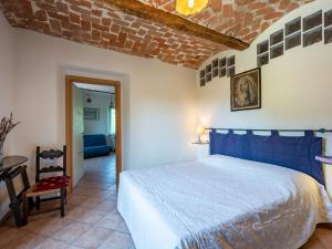 Un dormitorio con una cama azul y una pared de ladrillo en Apartment Cascina Villa - AST231 by Interhome, en Rocca D'Arazzo 15 fotos más