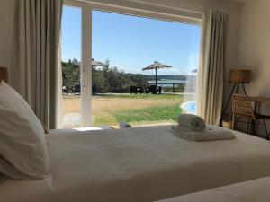 a bedroom with a bed with a view of the ocean at Herdade Do Freixial - Turismo Rural in Vila Nova de Milfontes