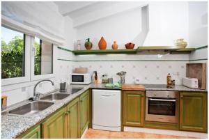 een keuken met groene kasten en een wastafel bij BINI CEL for 6 pax Heated Pool on request in Binibeca