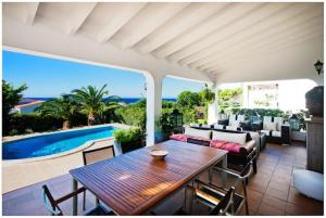 un patio con mesa, sofá y piscina en BINI CEL for 6 pax Heated Pool on request en Binibeca