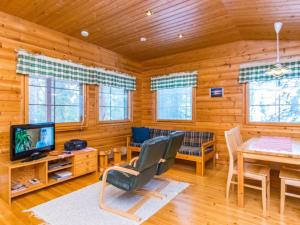 a living room with a dining table and a television at Holiday Home Ruskatupa by Interhome in Ruka
