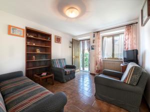 a living room with a couch and chairs and a tv at Holiday Home Il Castelliere-2 by Interhome in Rive dʼArcano