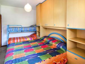 een slaapkamer met een bed met een kleurrijke deken bij Apartment Casa Lucrezia-1 by Interhome in Rosolina Mare