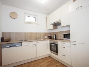 - une cuisine blanche avec des placards blancs et un évier dans l'établissement Apartment Matilda by Interhome, à Ried im Oberinntal