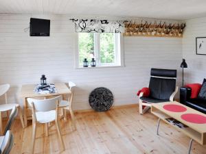 salon ze stołem, krzesłami i kanapą w obiekcie Chalet Grönede - OST006 by Interhome w mieście Kisa