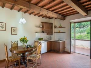 una cucina con tavolo in legno, tavolo e sedie di Apartment Vigna La Corte-3 by Interhome a Dicomano