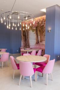 a dining room with a table and pink chairs at Hotel BCL Levante Club & Spa - Only Adults Recomended in Benidorm