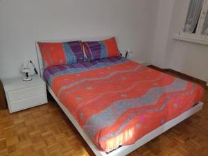 a bed with a colorful comforter in a bedroom at La finestra sul Brenta in Lasino