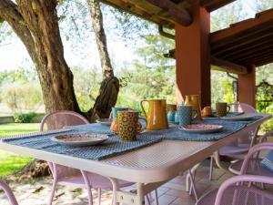 a table with plates and mugs on top of it at Villa Casal di Yuri by Interhome in Vetralla