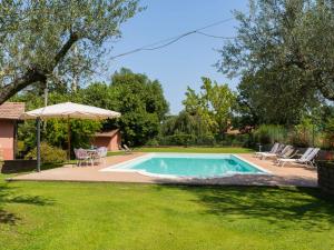 una piscina en un patio con sombrilla en Villa Casal di Yuri by Interhome, en Vetralla