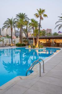 una piscina con palmeras en un complejo en Hotel BCL Levante Club & Spa 4 Sup - Only Adults Recomended, en Benidorm