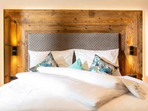 a bedroom with a large white bed with a wooden headboard at Apartment Apart Jasmin by Interhome in Ramsau im Zillertal