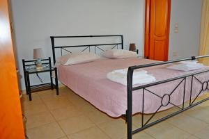 una camera da letto con un letto con lenzuola rosa e due tavoli di Kissamos Serene 3-bedroom Apartment a Kíssamos