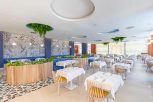 a dining room with white tables and chairs at Hotel BCL Levante Club & Spa 4 Sup - Only Adults Recomended in Benidorm