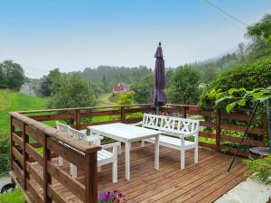 une terrasse en bois avec une table et un parasol dans l'établissement Holiday Home Gamlahuset - FJH667 by Interhome, à Bruntveit