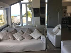 un soggiorno con divano bianco e cuscini di Villa Shambhala a San Bartolomeo al Mare