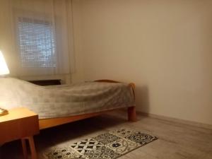 Un pat sau paturi într-o cameră la Baross Apartman