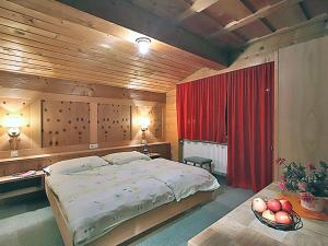 1 dormitorio con 1 cama grande y cortina roja en Apartment Ainhauser-2 by Interhome, en Rodund