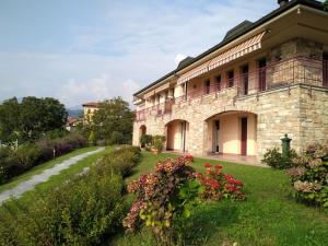 a stone building with a balcony on a yard at Holiday Home Achillea by Interhome in Due Cossani