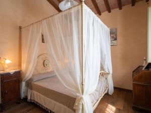a bedroom with a canopy bed with white curtains at Holiday Home Nido del Sorbino by Interhome in Fondaccio