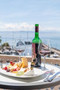 a table with a plate of food and wine glasses at Akzent Hotel Löwen in Langenargen