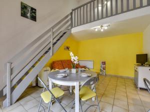 - un salon avec une table et des chaises ainsi qu'un escalier dans l'établissement Apartment Les Patios du Barcarès-2 by Interhome, au Barcarès