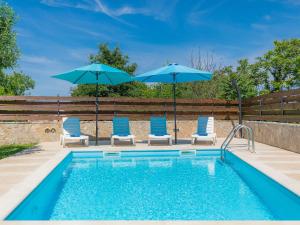a swimming pool with two chairs and two umbrellas at Holiday Home Nikolina - Roj412 by Interhome in Sveti Petar u Šumi