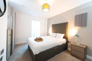 Un dormitorio con una cama con un osito de peluche. en Modern City Living Apartments at The Assembly Manchester en Mánchester