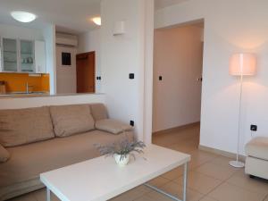 een woonkamer met een bank en een tafel bij Apartment Milevoj - RAC158 by Interhome in Rabac