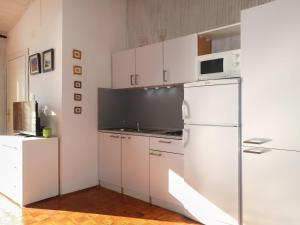 a kitchen with white cabinets and a refrigerator at Apartment Popara - JAD105 by Interhome in Jadranovo