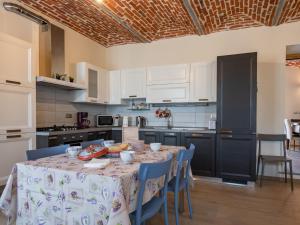 a kitchen with a table with blue chairs and white cabinets at Holiday Home Bricco delle Rondini by Interhome in Villata