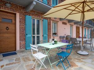 un tavolo e sedie con ombrellone su un patio di Holiday Home Bricco delle Rondini by Interhome a Villata