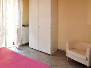 una camera con letto rosa e sedia di Apartment Roseto by Interhome a Cervo