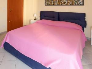 un grande letto con una coperta rosa sopra di Apartment Roseto by Interhome a Cervo
