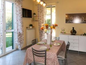 una sala da pranzo con tavolo e fiori di Apartment Roseto by Interhome a Cervo