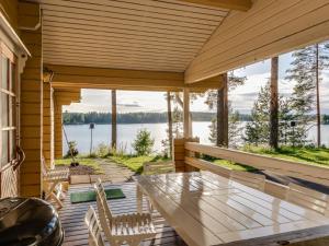 porche con mesa, sillas y vistas al agua en Holiday Home Konnusmaja by Interhome, en Leppävirta