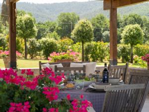 a dining table with pink flowers on a patio at Holiday Home Santa Lucia by Interhome in Castiglion Fiorentino