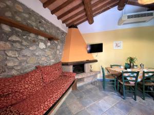 Una sala de estar con un sofá rojo y una chimenea. en Holiday Home Orso by Interhome, en Riparbella 37 fotos más