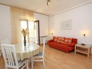 Una sala de estar con una mesa y un sofá rojo. en Apartment Marija by Interhome, en Supetar