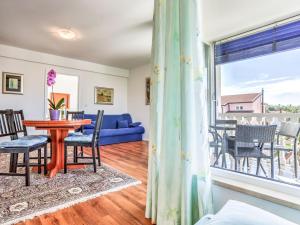 a living room with a table and chairs and a window at Apartment File-4 by Interhome in Zambratija +16 photos