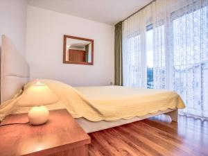 a bedroom with a bed and a table with a lamp at Apartment File-4 by Interhome in Zambratija