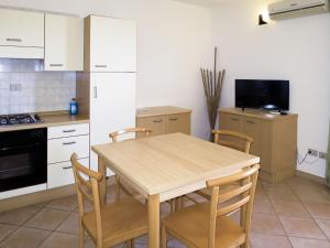 una cucina con tavolo e sedie in legno di Apartment Il Borgo - PCR215 by Interhome a Villaputzu