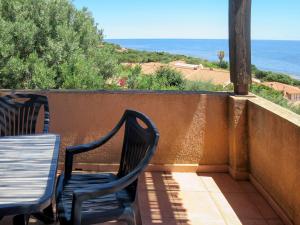 2 sedie e un tavolo sul balcone con vista sull'oceano di Apartment Il Borgo - PCR215 by Interhome a Villaputzu