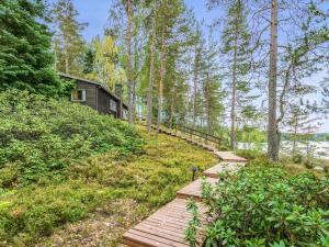 um caminho de madeira que leva a uma cabana na floresta em Holiday Home Ranta-iivari by Interhome em Lohja