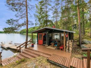 uma cabana na água com um deck de madeira em Holiday Home Ranta-iivari by Interhome em Lohja